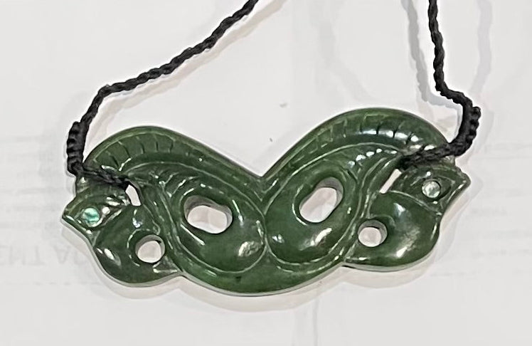 Greenstone jade necklace with intricate design on a white background