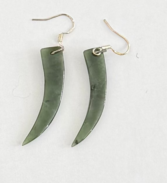 Pair of Greenstone horn-shaped earrings on a white background