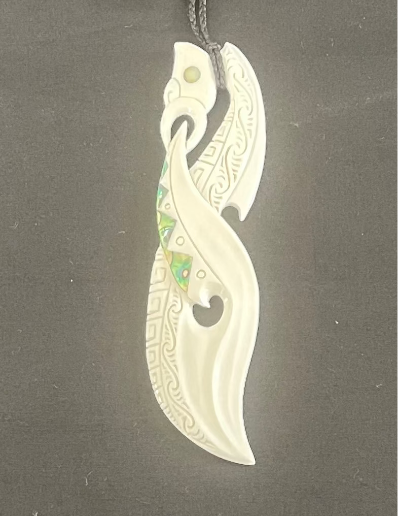 Carved bone pendant on a dark gray background