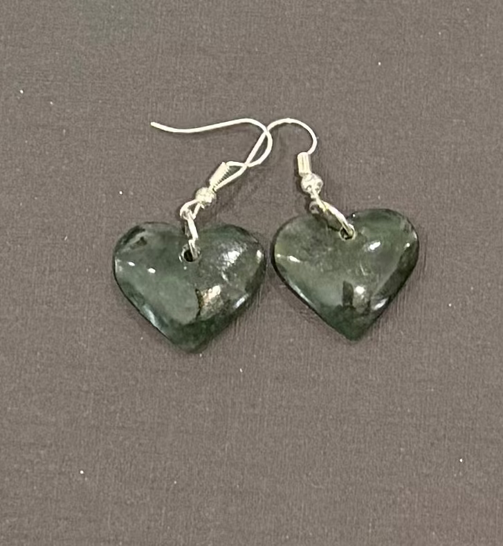Heart-shaped greenstone earrings on a gray background