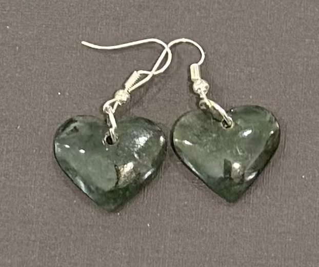 Heart-shaped greenstone earrings on a gray background