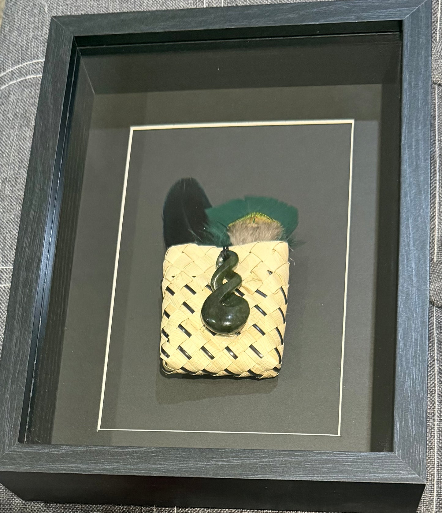 Greenstone twist in a Kete with feathers Framed