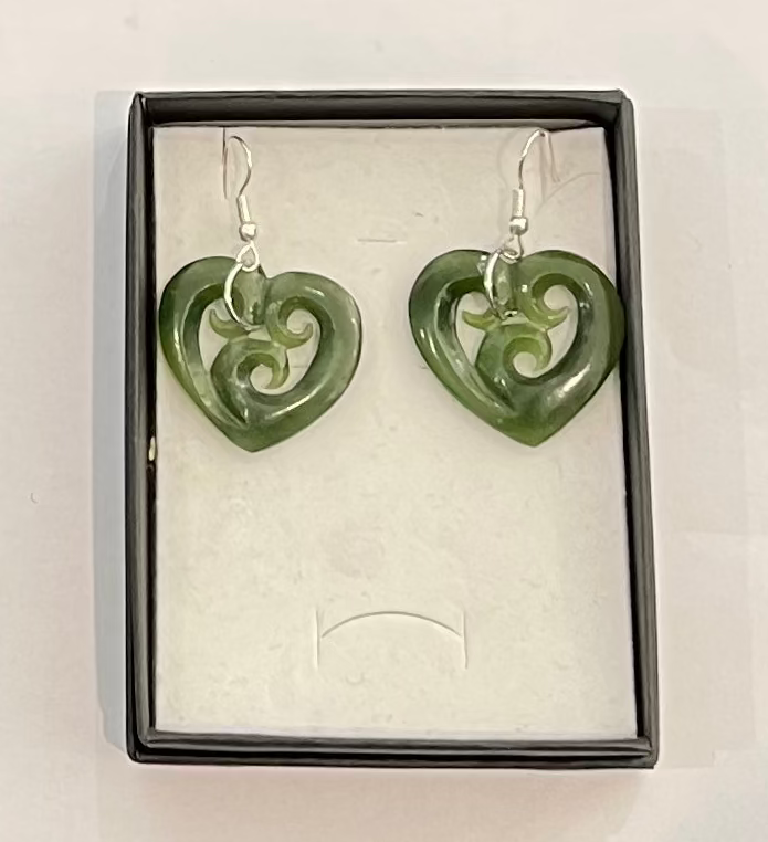 Greenstone heart-shaped earrings with silver hooks in a box on a white background