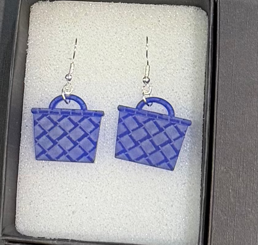 A pair of blue basket-shaped dangle earrings with silver fishhook wires, displayed inside a black gift box with white foam insert.