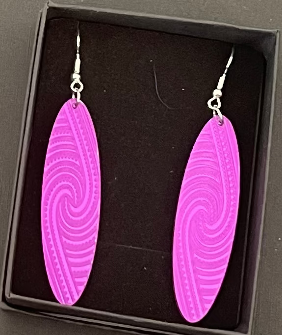Purple spiral earrings in a black box on a gray background