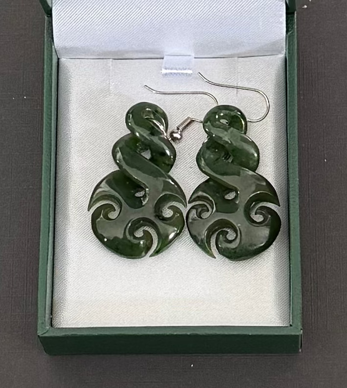 Greenstone earrings in a jewelry box with visible brand name.