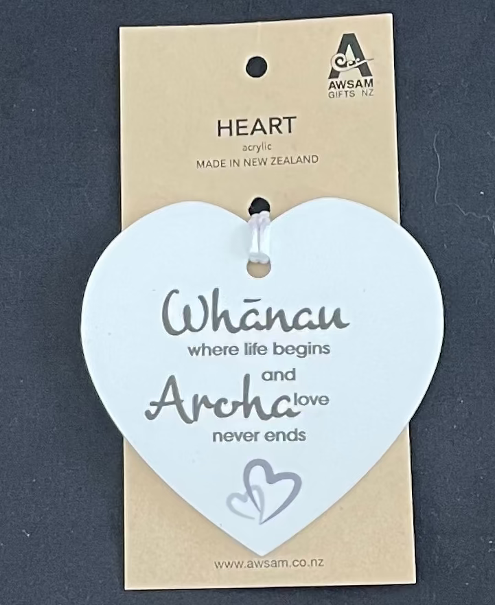 Heart-shaped acrylic plaque with text on a beige card, against a dark background