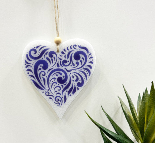 Heart-shaped ceramic ornament with blue pattern on a white background