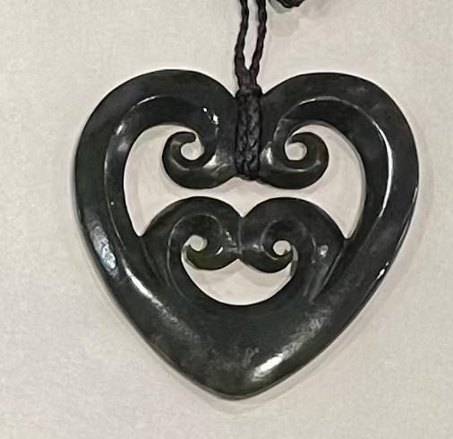 Heart-shaped pendant with intricate design on a white background
