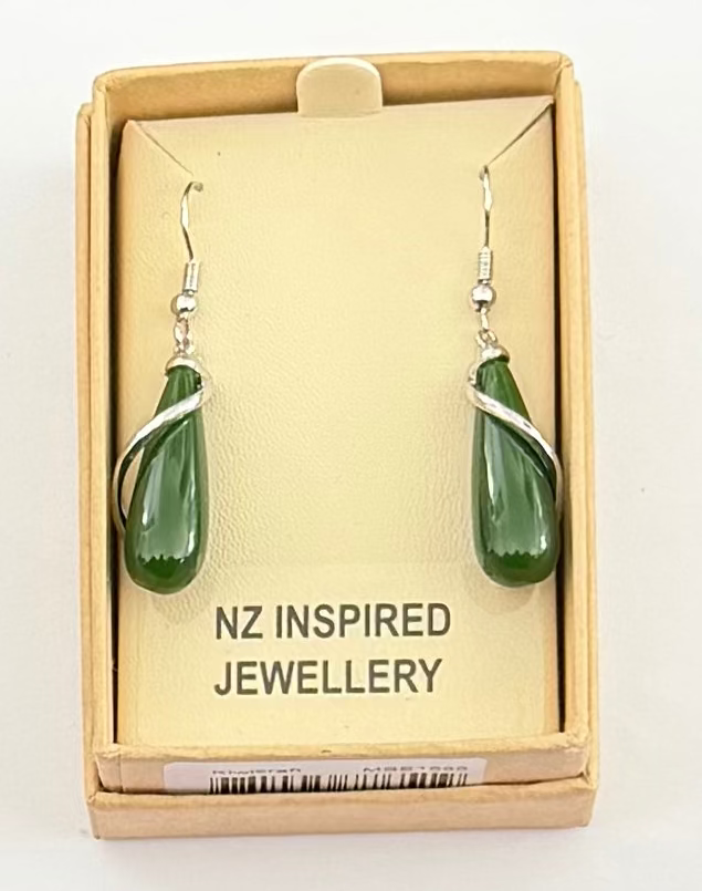 A pair of green jade teardrop earrings with silver wire wrapping and silver fishhook ear wires, presented in a light brown cardboard jewelry box with a cream insert that reads 'NZ INSPIRED JEWELLERY'.