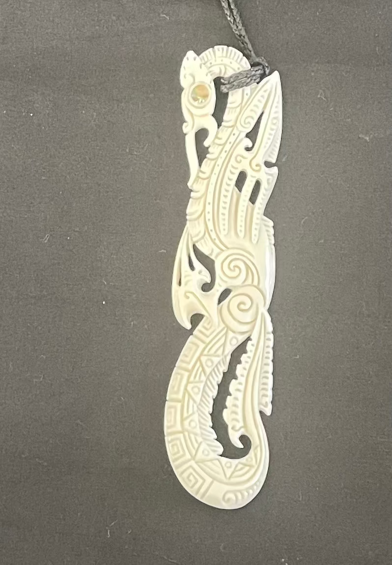 Carved bone pendant on a gray background