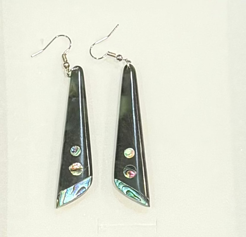 Pair of triangular earrings with colorful stones on a white background
