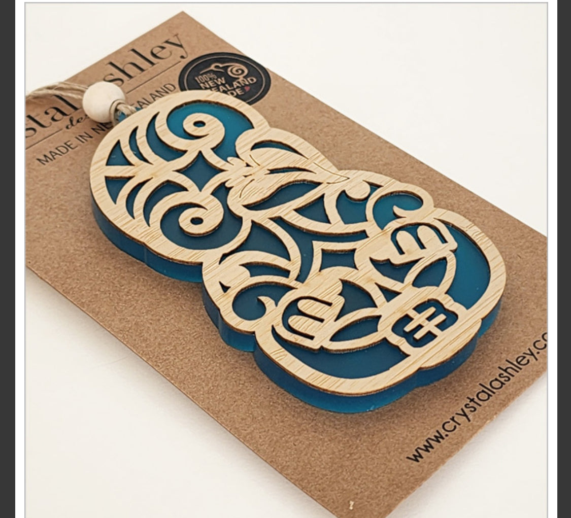 Wooden and blue decorative item on a cardboard backing with 'Crystal Ashley' branding.