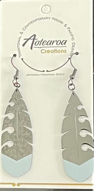 Feather-shaped maori earrings on a branded card.