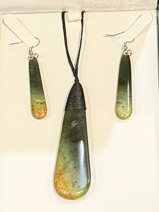 Greenstone teardrop pendant with black cord and matching earrings on a white card.