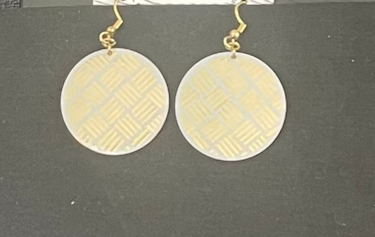 Pair of round earrings with a geometric pattern on a black background