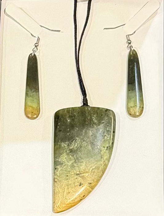 Jade greenstone pounamu pendant and earrings set in a display box on a textured surface