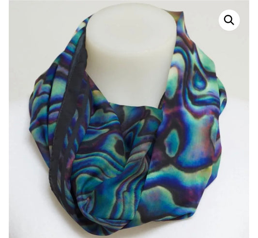 A loop infinity scarf with an abstract marbled pattern in shades of teal, blue, purple, and black, displayed on a white mannequin bust against a plain white background.