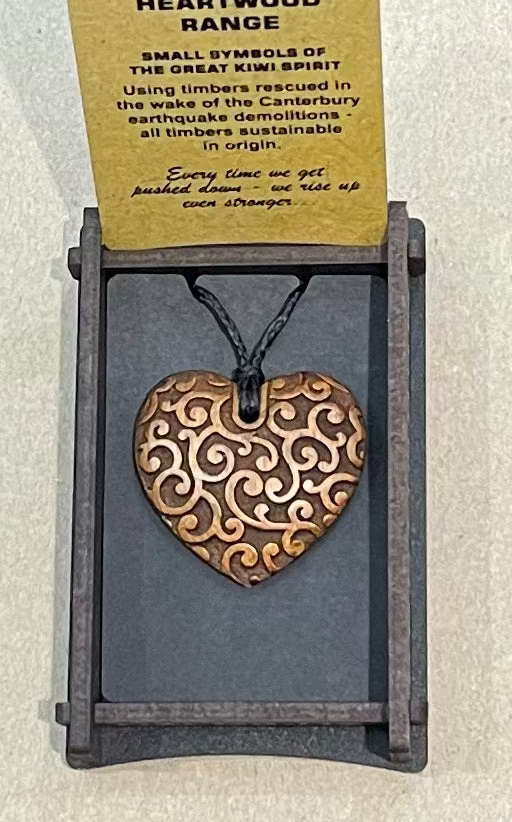 Bronze heart-shaped pendant on a card with text