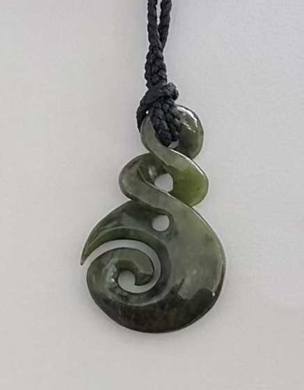 Green jade spiral pendant on a white background