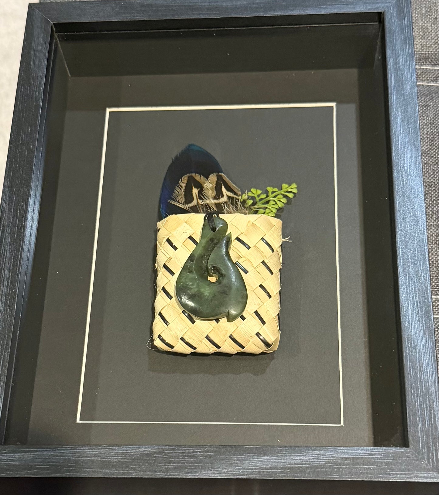 Greenstone Hook in a Kete with Feathers Framed