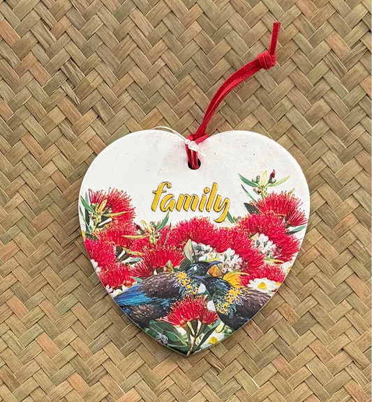 Heart-shaped ornament with floral design and 'family' text on a woven surface