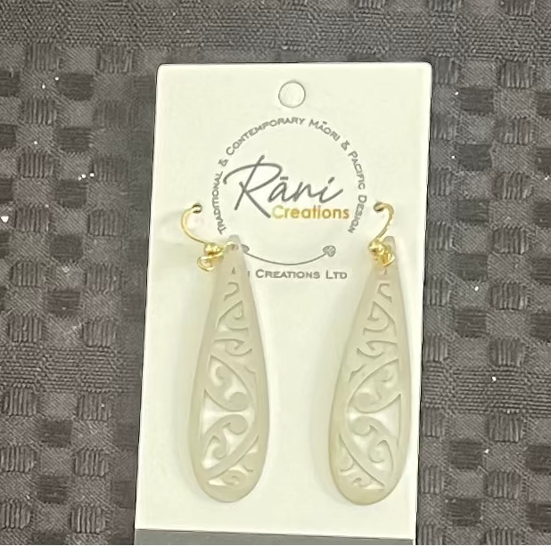 Teardrop-shaped maori earrings on a Rani Creations card against a textured gray background
