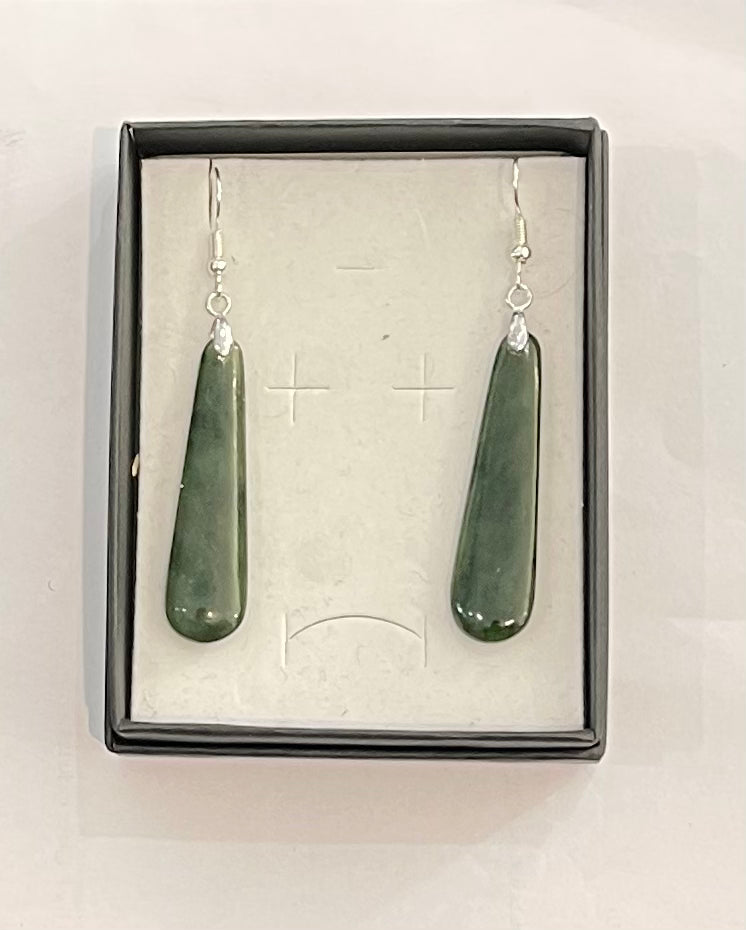 Green stone earrings in a box on a white background