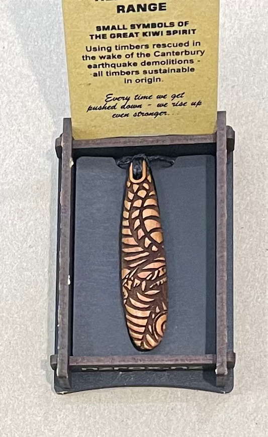 Wooden pendant with zebra pattern on a display card with text