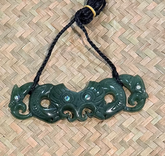 Greenstone jade pendant on a woven mat