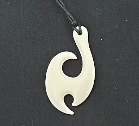 Bone pendant on a black cord against a black background