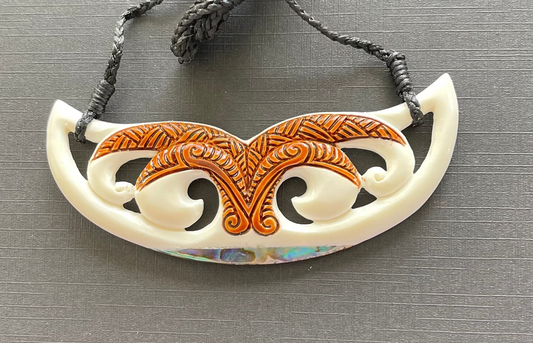 Decorative bone necklace with intricate design on a gray background