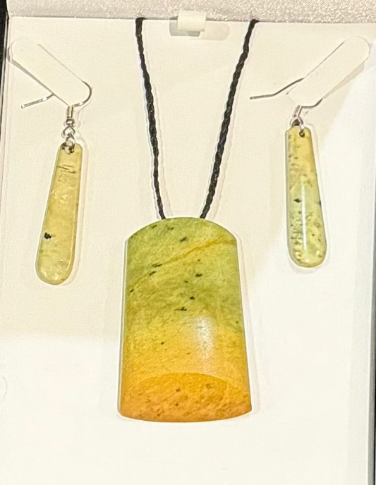 Jewelry set with greenstone pendant and earrings on a white background
