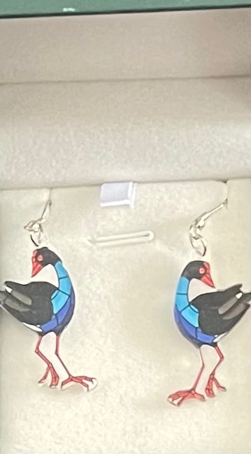 Bird-shaped Pukeko earrings on a display card with a neutral background