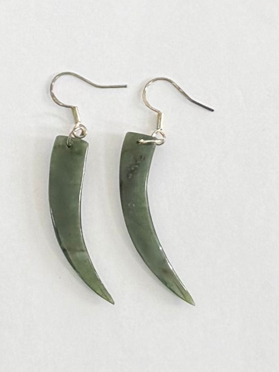 Pair of green horn-shaped Greenstone  earrings on a light gray background