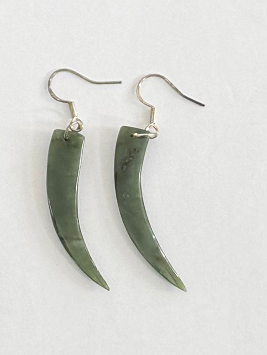 Pair of green horn-shaped Greenstone  earrings on a light gray background