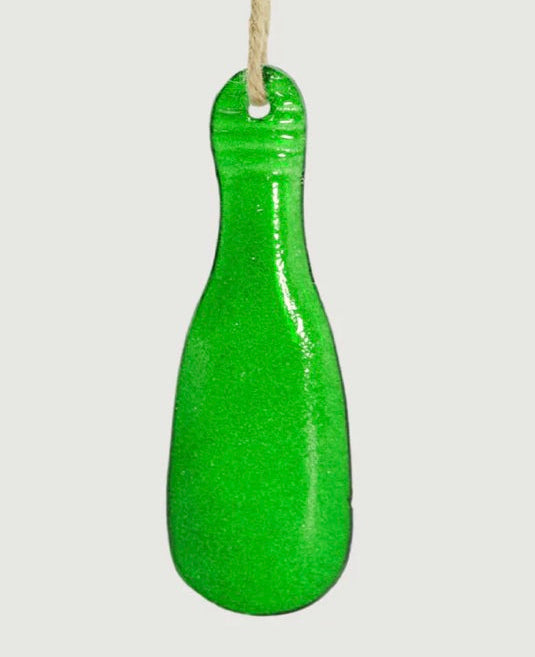 Green glass patu-shaped ornament hanging on a white background