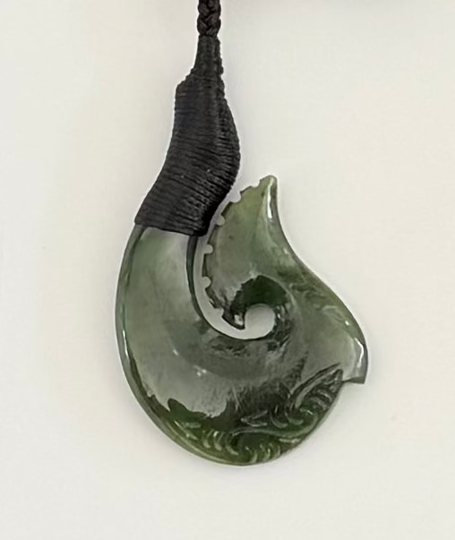 Greenstone hook jade necklace pendant on a white background