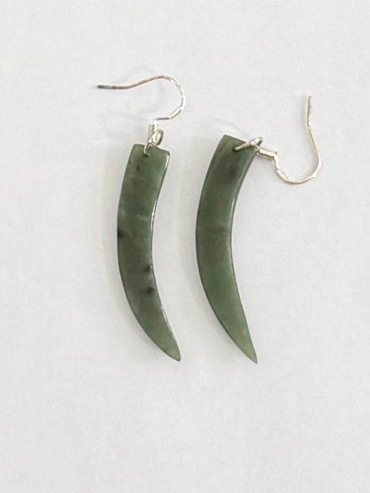Pair of Greenstone  horn-shaped earrings on a light gray background