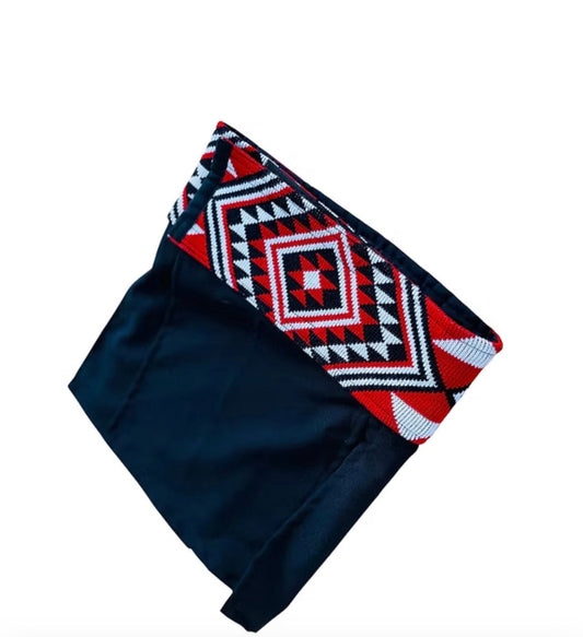 Black fabric with a red, white, and blue geometric taniko pattern on a white background 