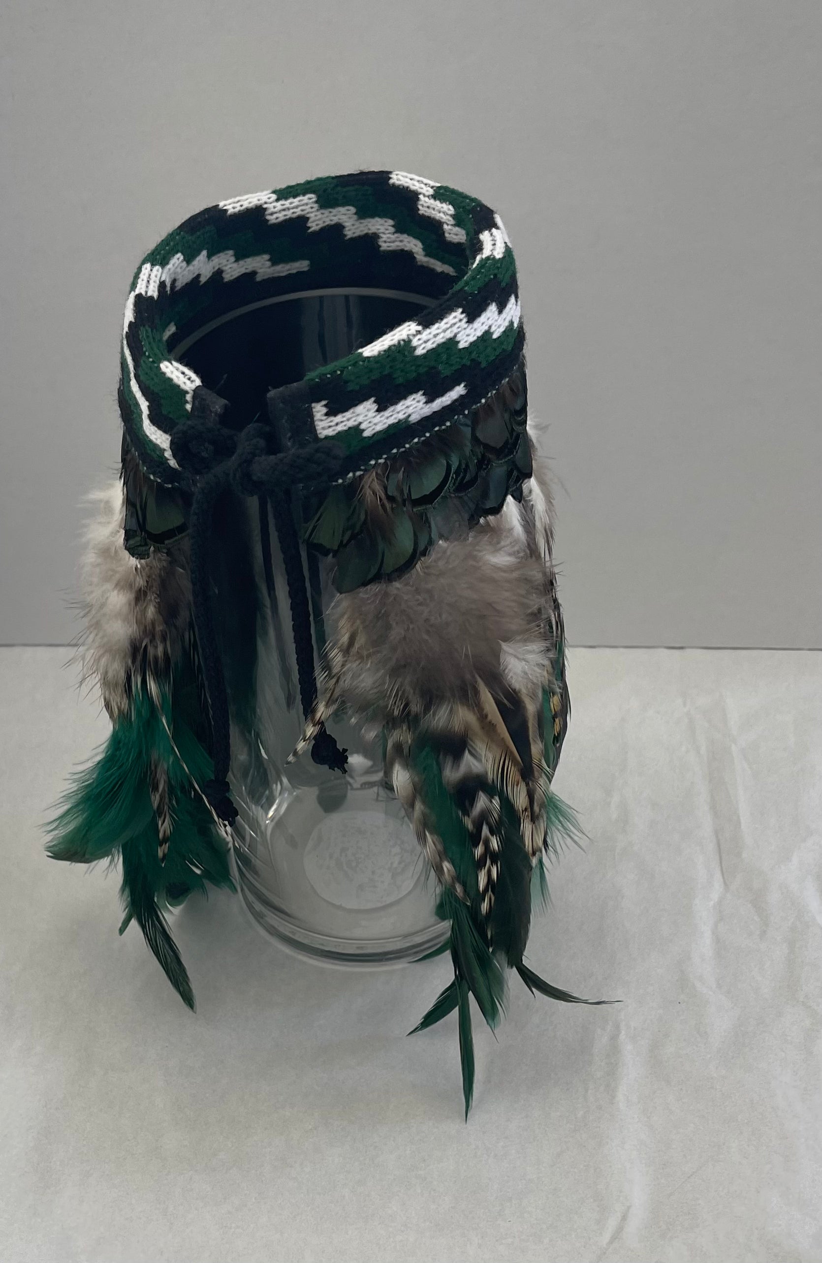 Mini bottle green Korowai on a white background