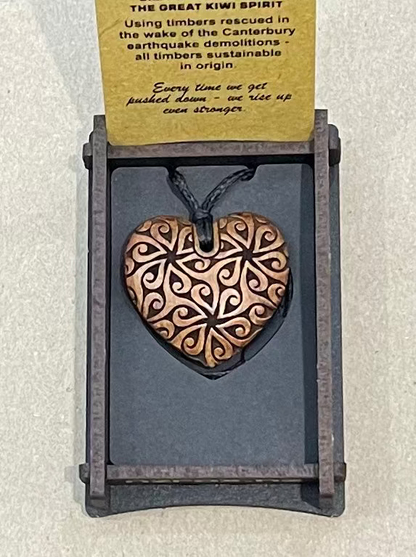 Heart-shaped pendant on a card with text on a light gray background