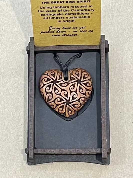 Heart-shaped pendant on a card with text on a light gray background