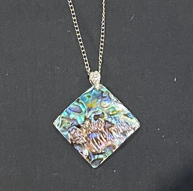Paua shell Necklace with a square, multicolored pendant on a dark background