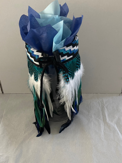 Decorative Maori mini korowai with paper on a white surface