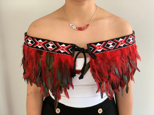 Red feathered Maori cape with taniko band