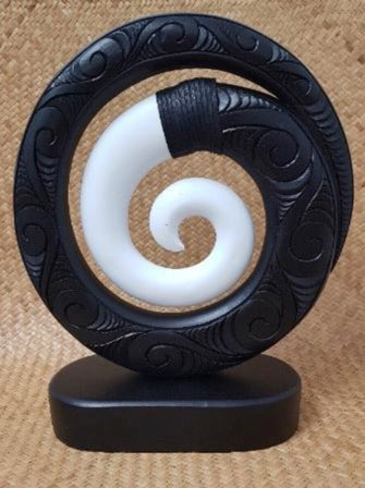 Wood carved koru with black & white resin on a base